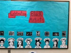 Photo shows a bulletin board featuring black and white drawings of famous African American artists.